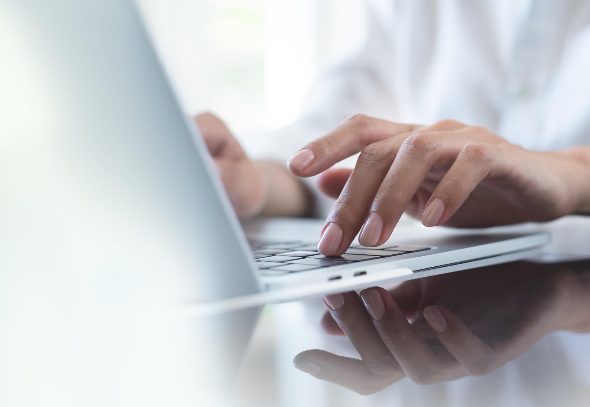 Woman's hand typing on a laptop keyboard