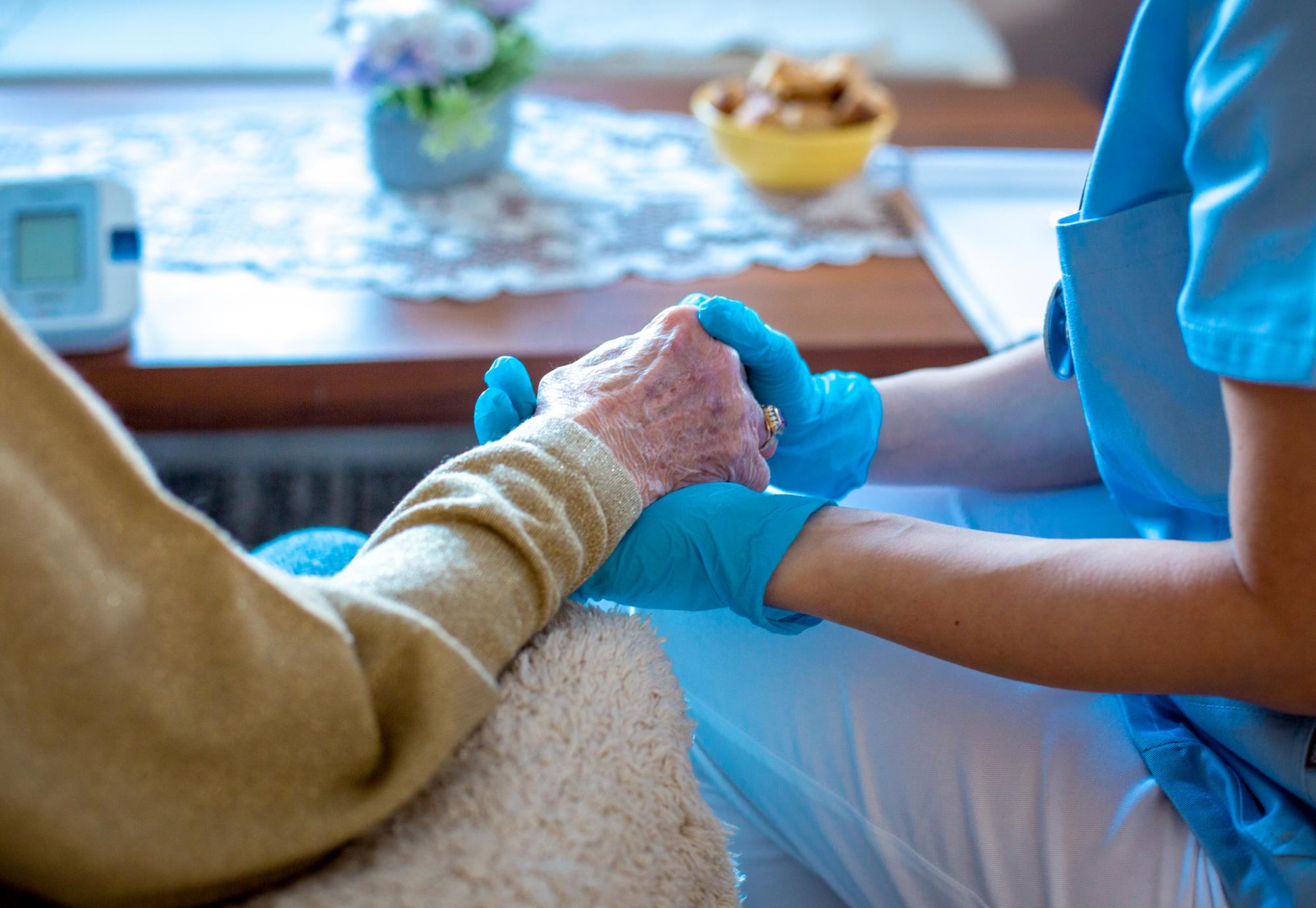 Young female doctor is holding her patient's hand