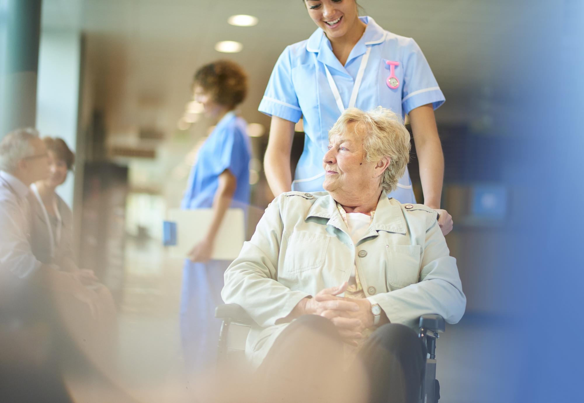 An elderly hospital patient sits in a wheelchair