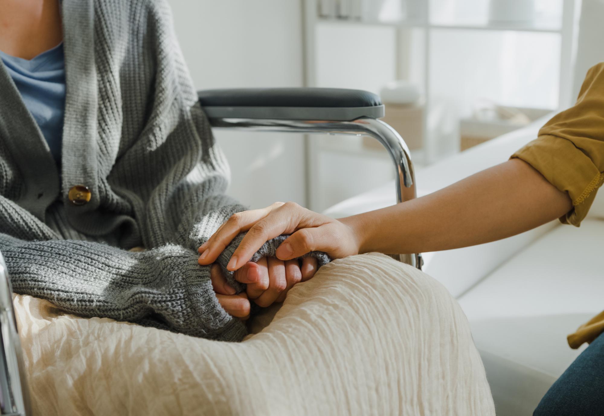 Close up of two people holding hands, one has leukemia