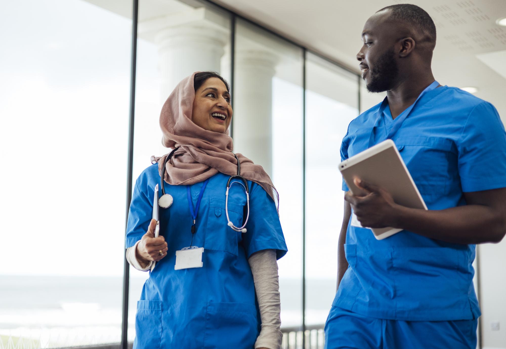 Two healthcare professionals walking in a corridor