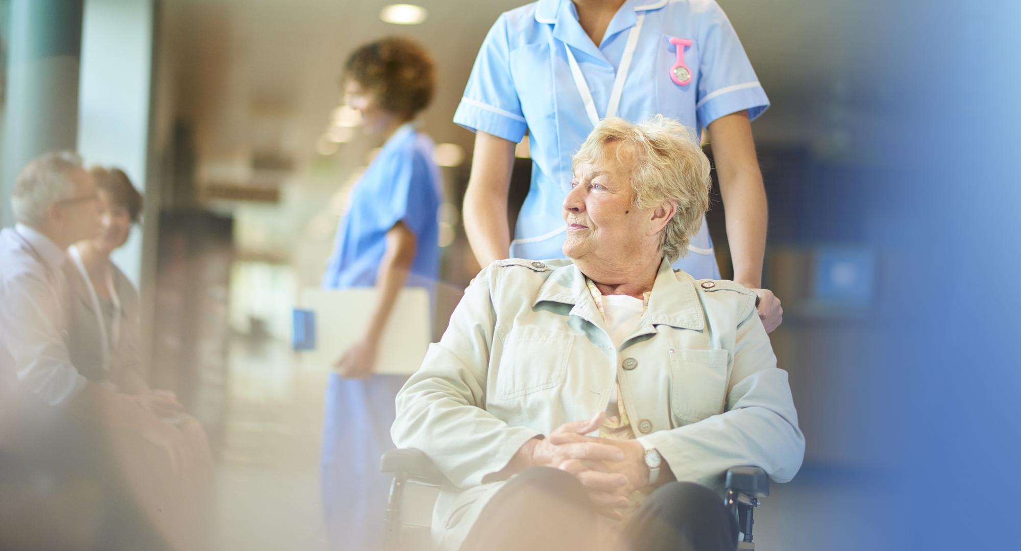 An elderly hospital patient sits in a wheelchair