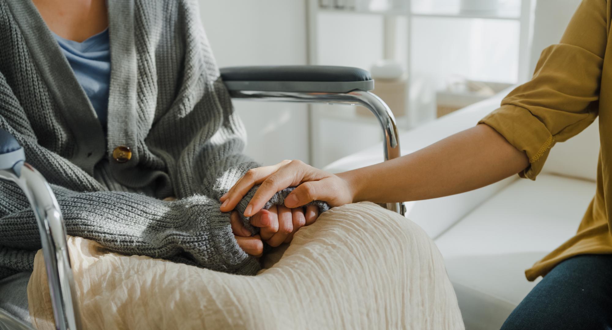 Close up of two people holding hands, one has leukemia