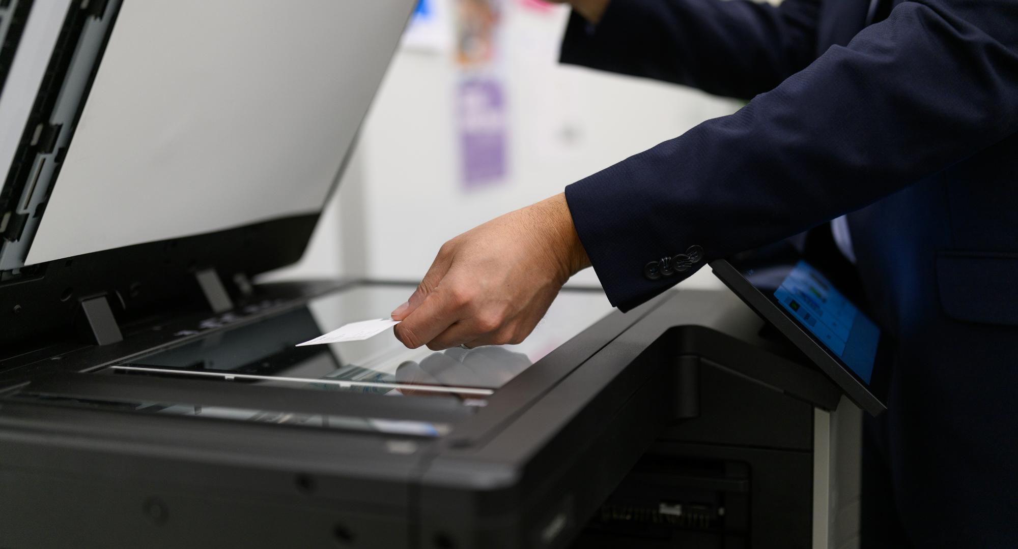 Person placing business card in a scanner