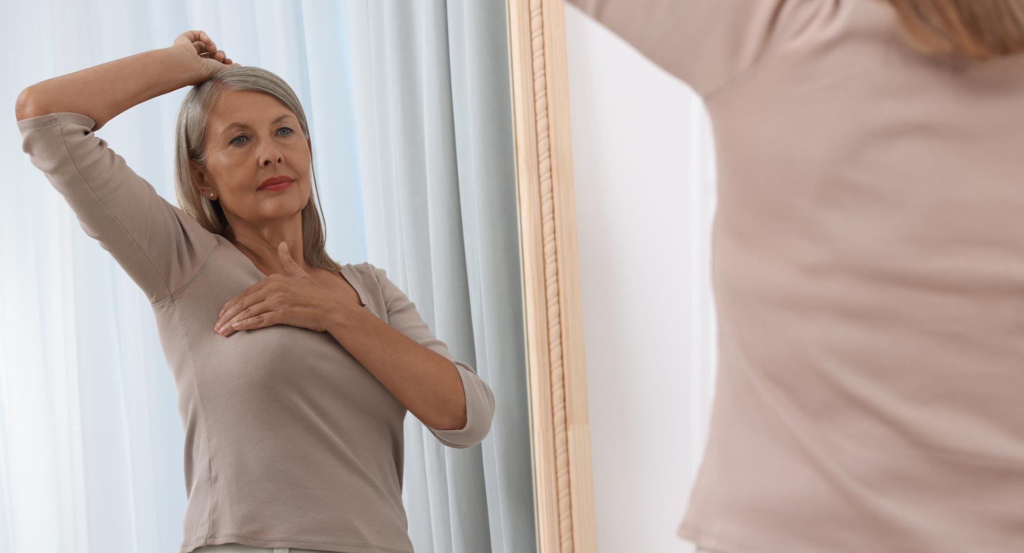 Senior woman checking for breast cancer