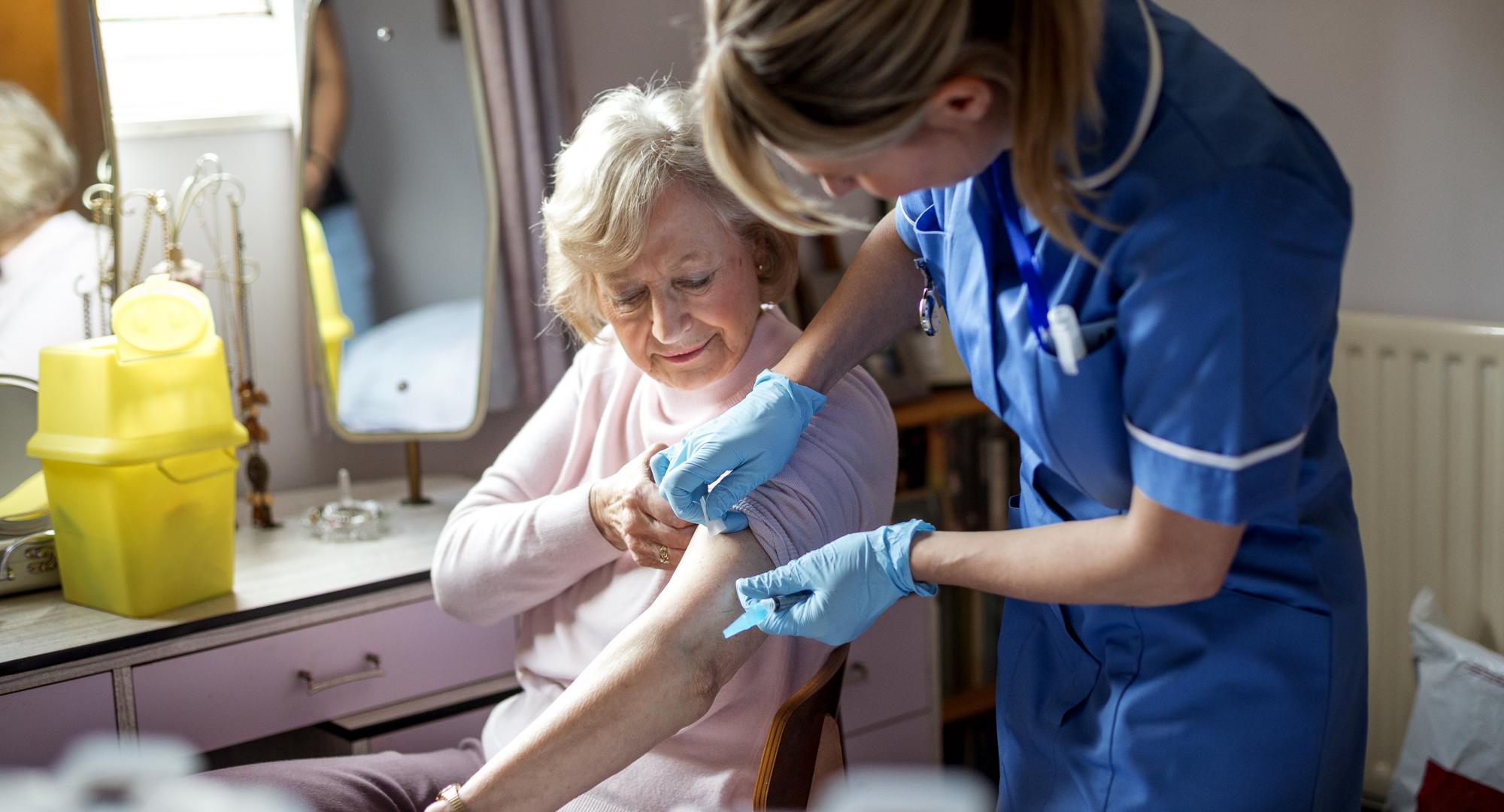 Elderly woman being vaccinated