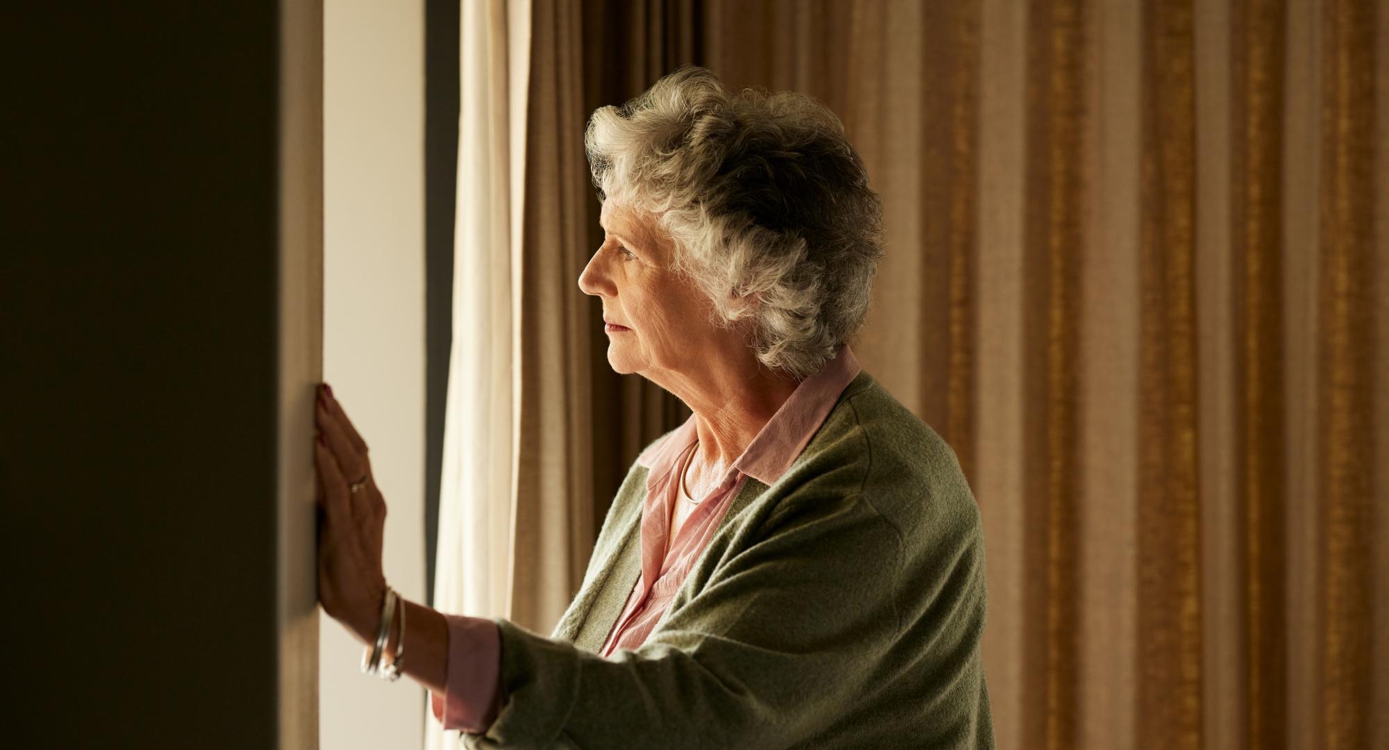 Lonely woman looking out of the window