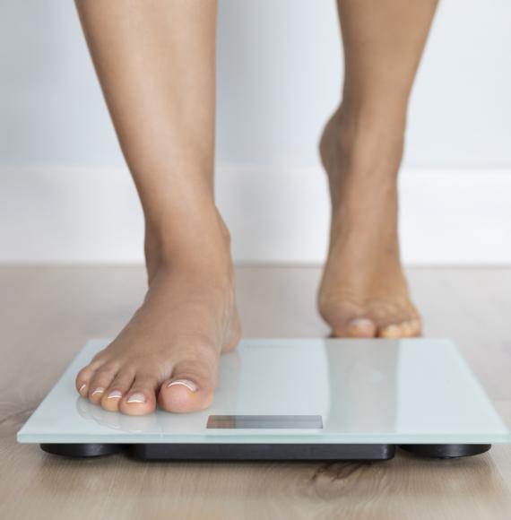 Woman getting on a weighing scale