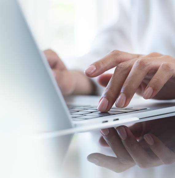 Woman's hand typing on a laptop keyboard