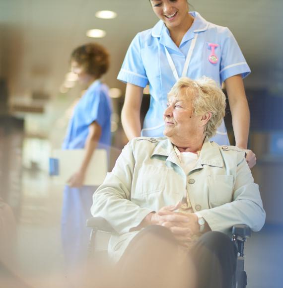 An elderly hospital patient sits in a wheelchair