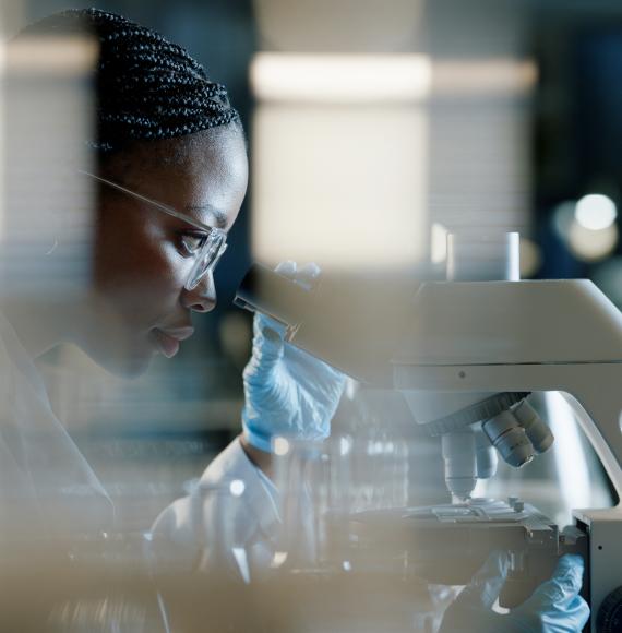 Scientist using a microscope for health research