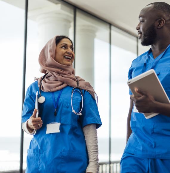 Two healthcare professionals walking in a corridor